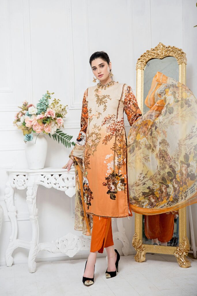 women in orange churidar with designs