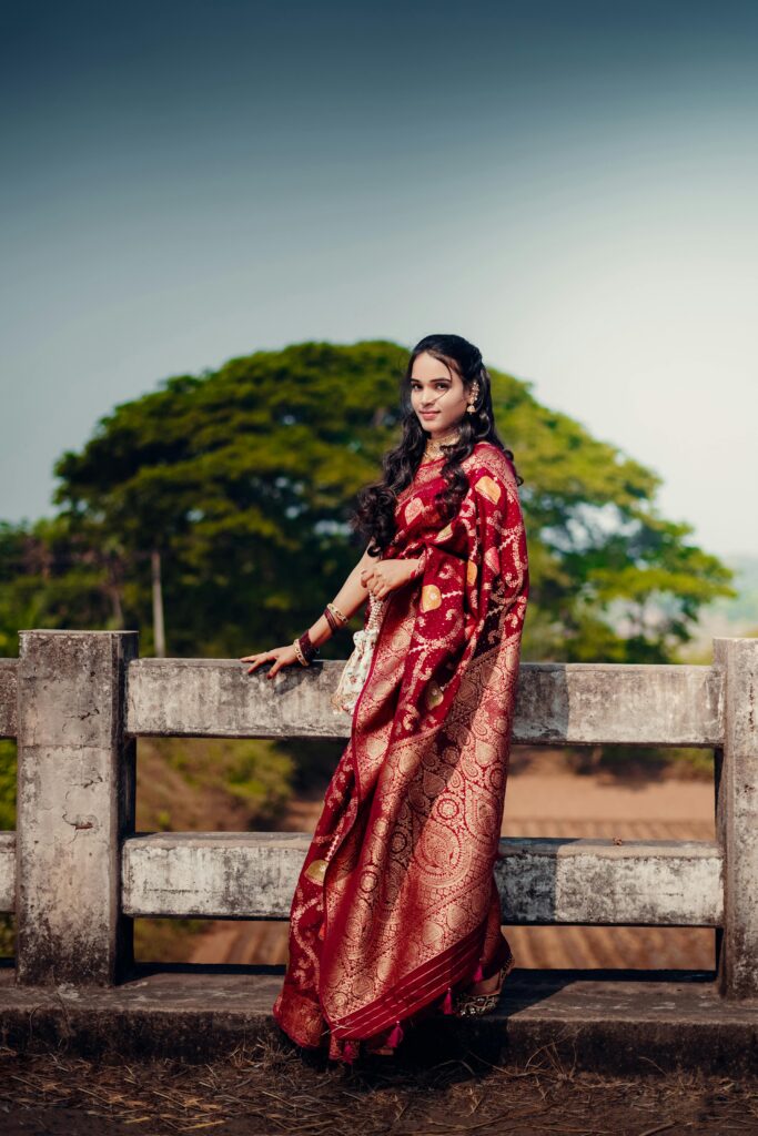 Model posing on a bridge in dark brown saree